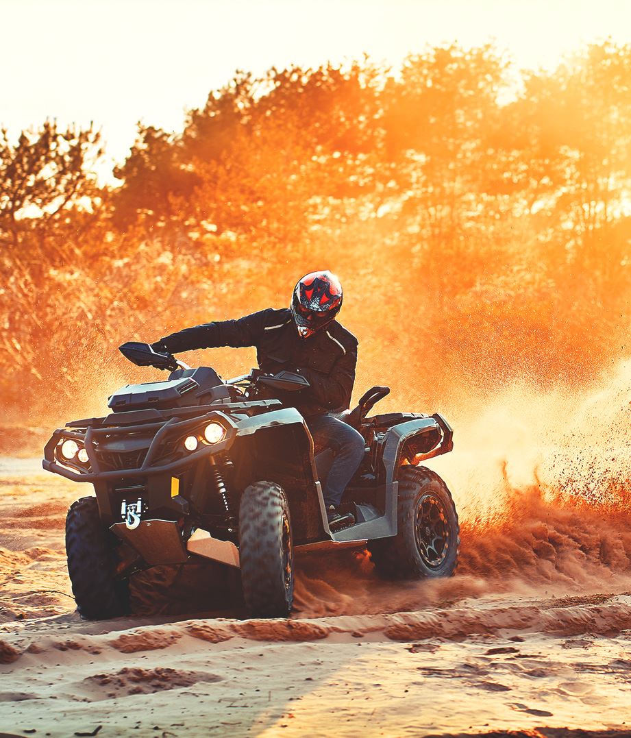 Person riding ATV on sand