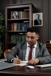 An attorney writing at his desk.