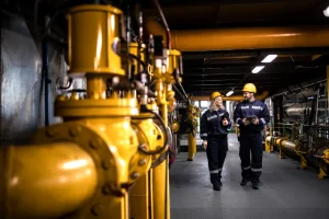 Two oil and gas workers walking through the plant.