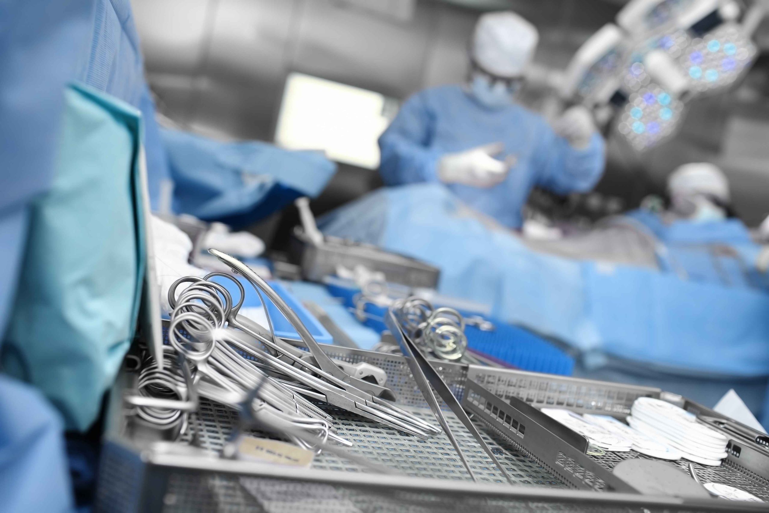 Surgical instruments in the foreground of a surgery.