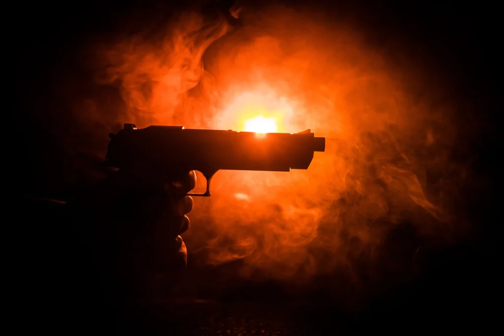 A gun being pointed sideways in the dark.